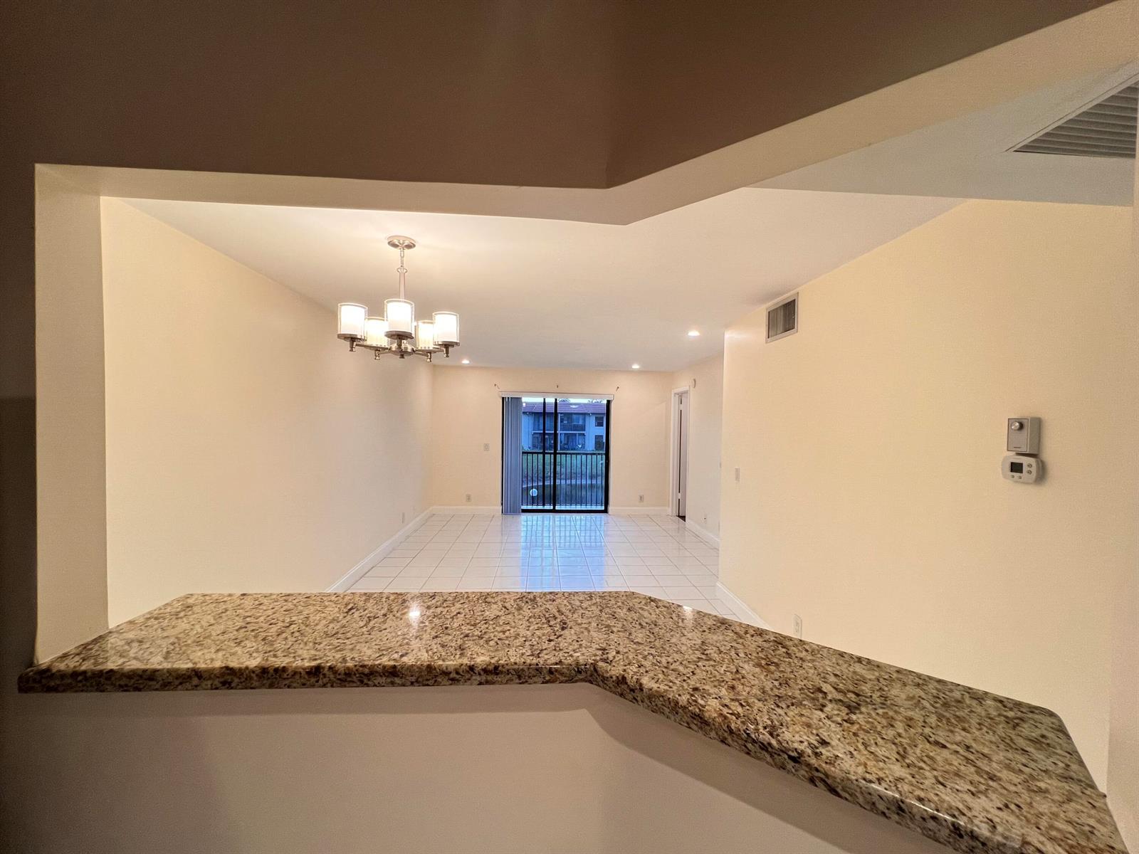 A view from a kitchen counter looking into an open living area with tile floors — 21911 Lake Forest Circle # 206, Boca Raton FL 33433, BOCA RATON, FL