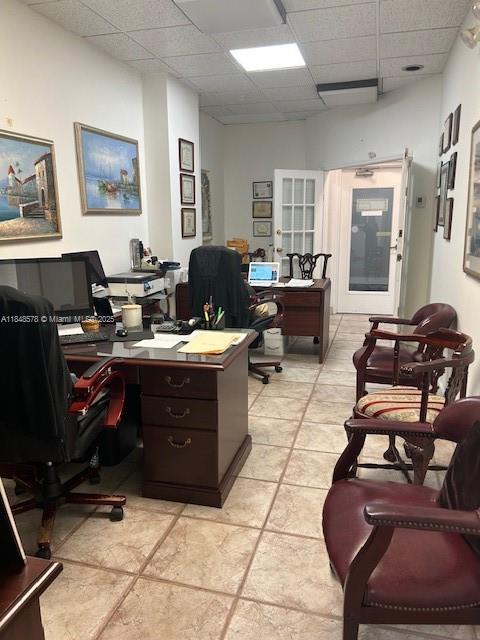 An office space features a wooden desk, rolling chairs, and framed artwork on the walls — 5601 Collins Ave, Miami Beach FL 33140, MIAMI BEACH, FL