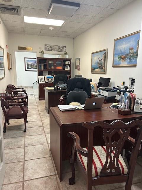 An office features a wooden desk, several chairs, and framed artwork on the walls — 5601 Collins Ave, Miami Beach FL 33140, MIAMI BEACH, FL
