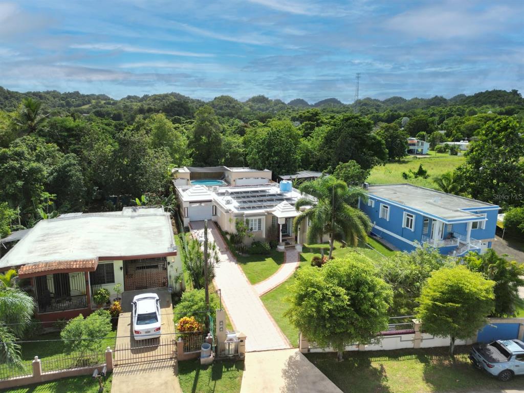 An aerial view shows a house with solar panels and a pool between two homes — 478 SAN ANTONIO, QUEBRADILLAS, PR