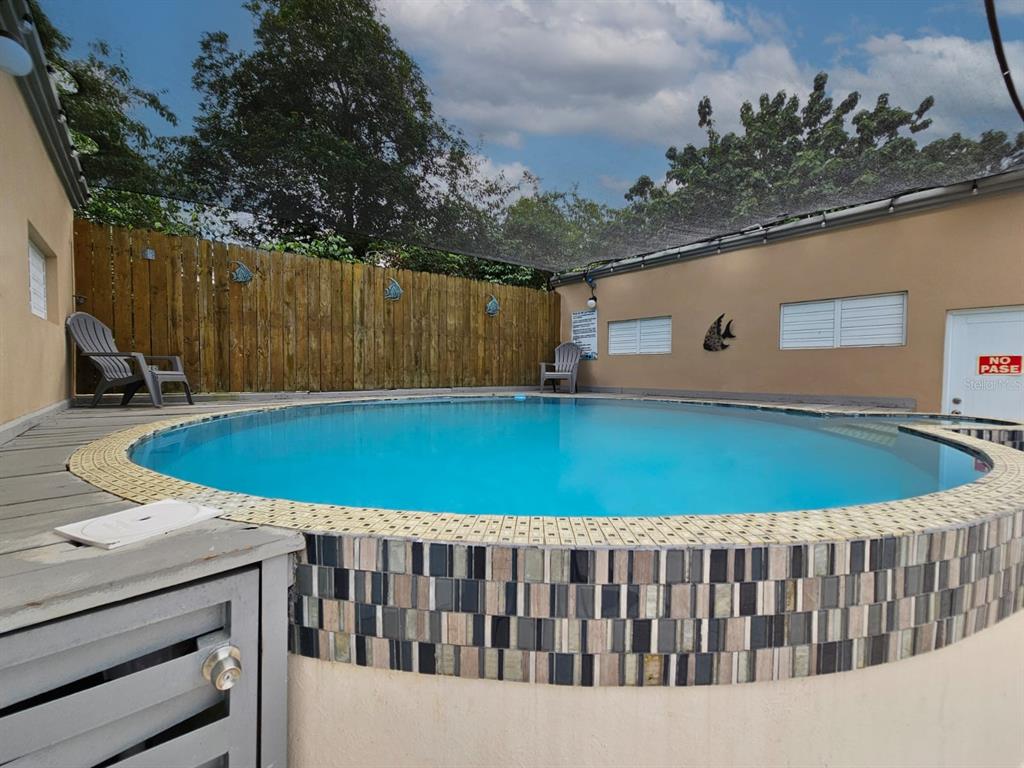 An above-ground circular swimming pool with tiled edges sits on a wooden deck — 478 SAN ANTONIO, QUEBRADILLAS, PR