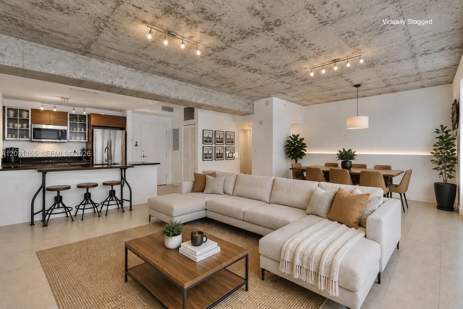 This virtually staged open-concept living area features a concrete ceiling, kitchen island, and dining space — 3449 NE 1st Ave # 109, Miami FL 33137, MIAMI, FL