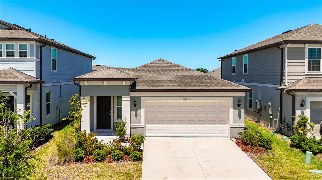 A single-story suburban house with a two-car garage and a small front yard — 6080 JENSEN VIEW AVENUE, APOLLO BEACH, FL