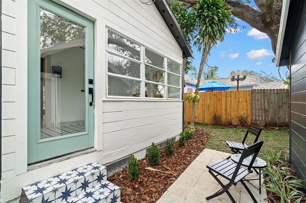 A white exterior wall with a light green door, patterned steps, and a small patio — 4536 1ST AVENUE N, ST PETERSBURG, FL