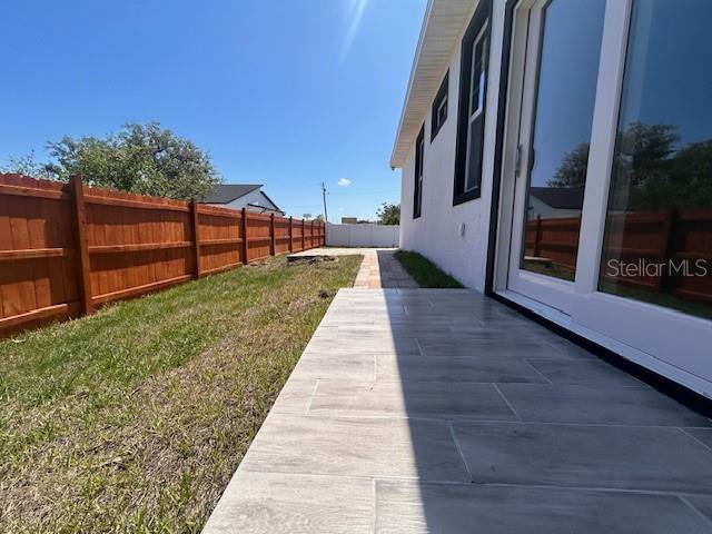 A tiled patio runs along the side of a house next to a wooden fence — 310 GIBSON AVENUE, LAKE WALES, FL
