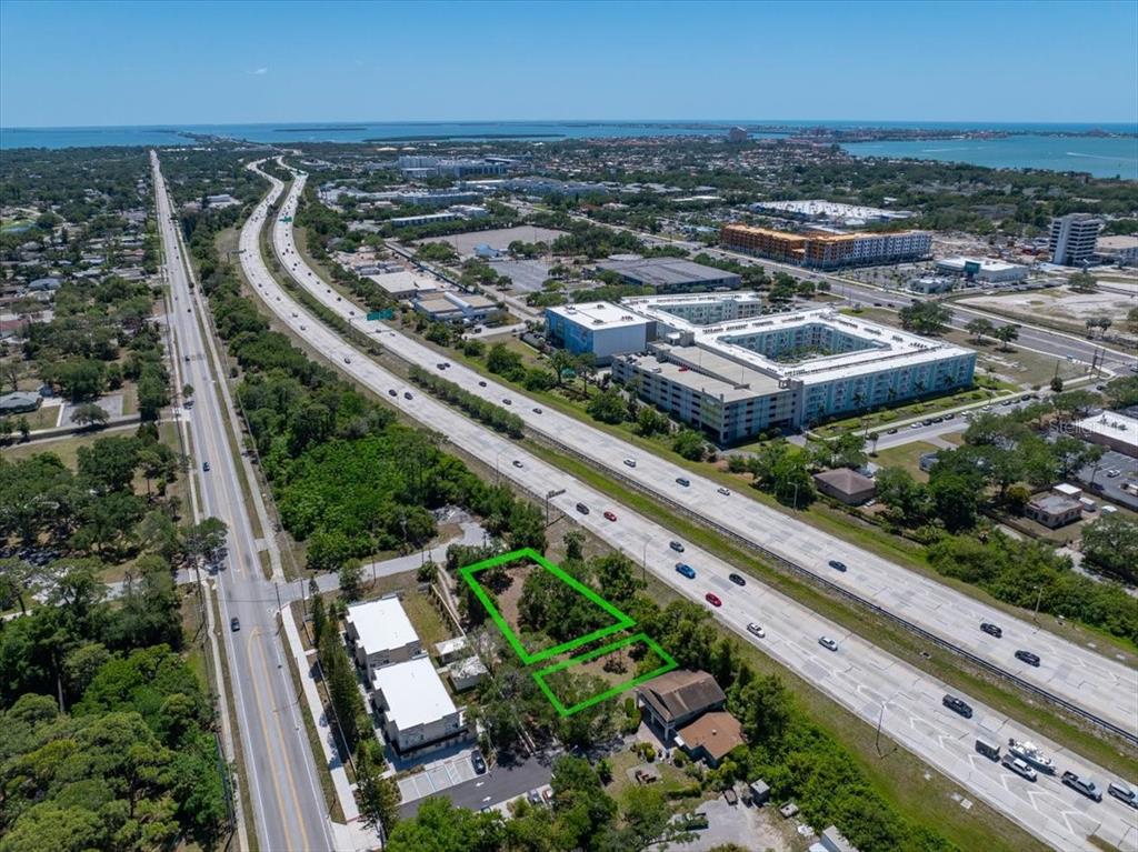 An aerial view shows two adjacent vacant lots outlined in green next to a highway — 30TH AVENUE S, ST PETERSBURG, FL
