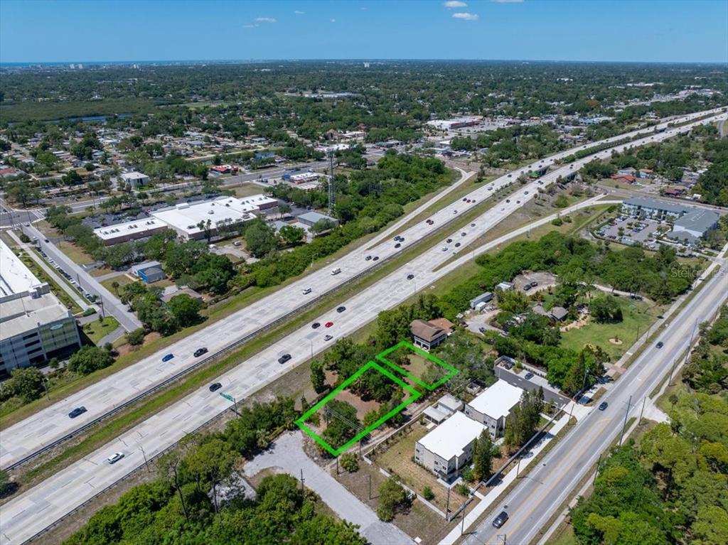 An aerial view shows two adjacent vacant lots outlined in green next to a highway — 30TH AVENUE S, ST PETERSBURG, FL