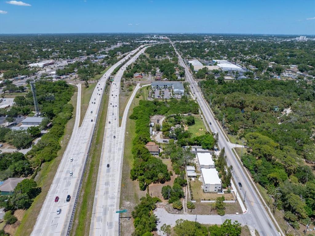 An aerial view shows a multi-lane highway running parallel to a local road and trees — 30TH AVENUE S, ST PETERSBURG, FL