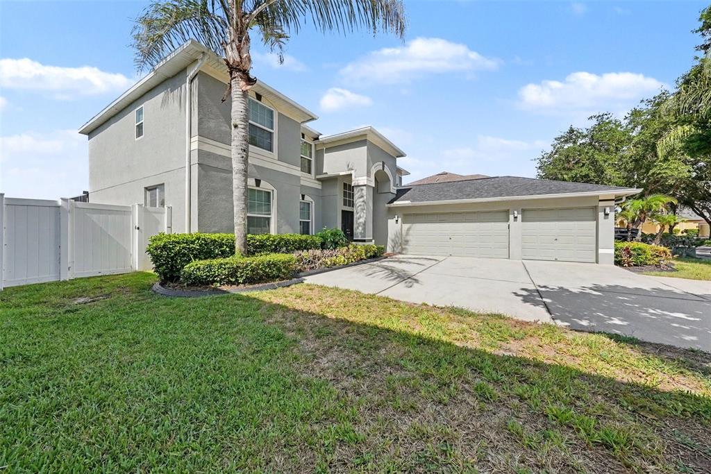 A two-story house with a gray stucco exterior, a two-car garage, and a palm tree — 4227 BALINGTON DRIVE, VALRICO, FL