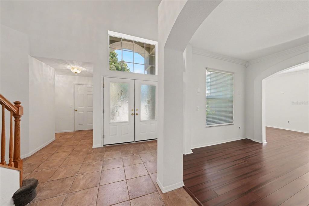 An entryway with tile flooring, a double front door, and an adjacent room with wood flooring — 4227 BALINGTON DRIVE, VALRICO, FL