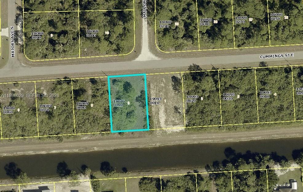 This is an aerial map showing a vacant rectangular lot highlighted in blue — 1230 E Cumming St, Lehigh Acres FL 33974, LEHIGH ACRES, FL