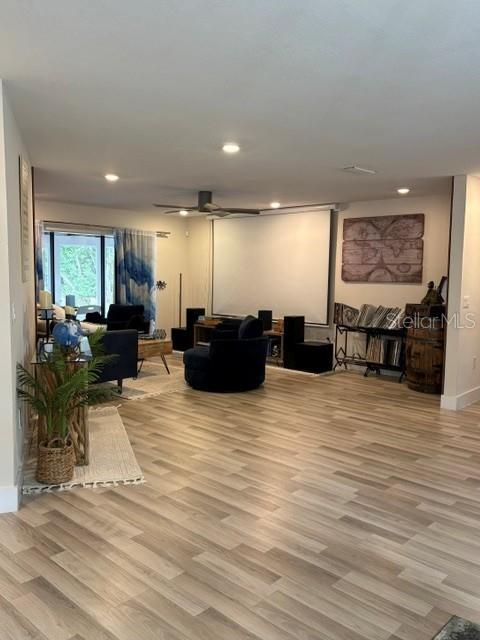 A living room features light wood-look flooring, a projector screen, and a dark armchair — 101 CHERRY HILL CIRCLE, LONGWOOD, FL