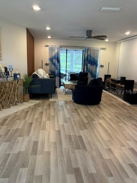 A living room features light wood-look flooring, a dark sofa, and a matching armchair — 101 CHERRY HILL CIRCLE, LONGWOOD, FL