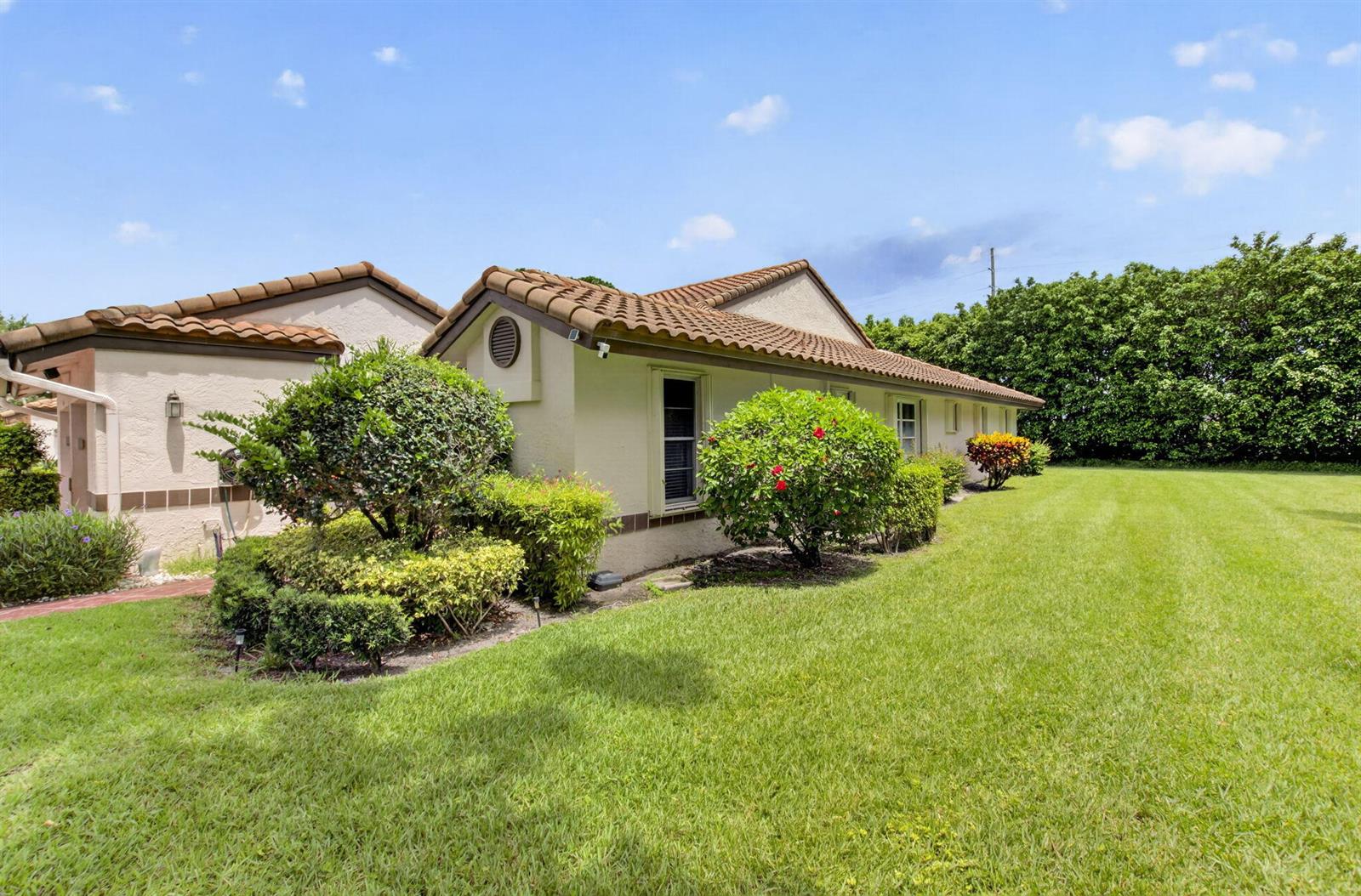 A single-story house with a tiled roof and landscaped yard under a blue sky — 6082 Waldwick Circle, Delray Beach FL 33484, DELRAY BEACH, FL