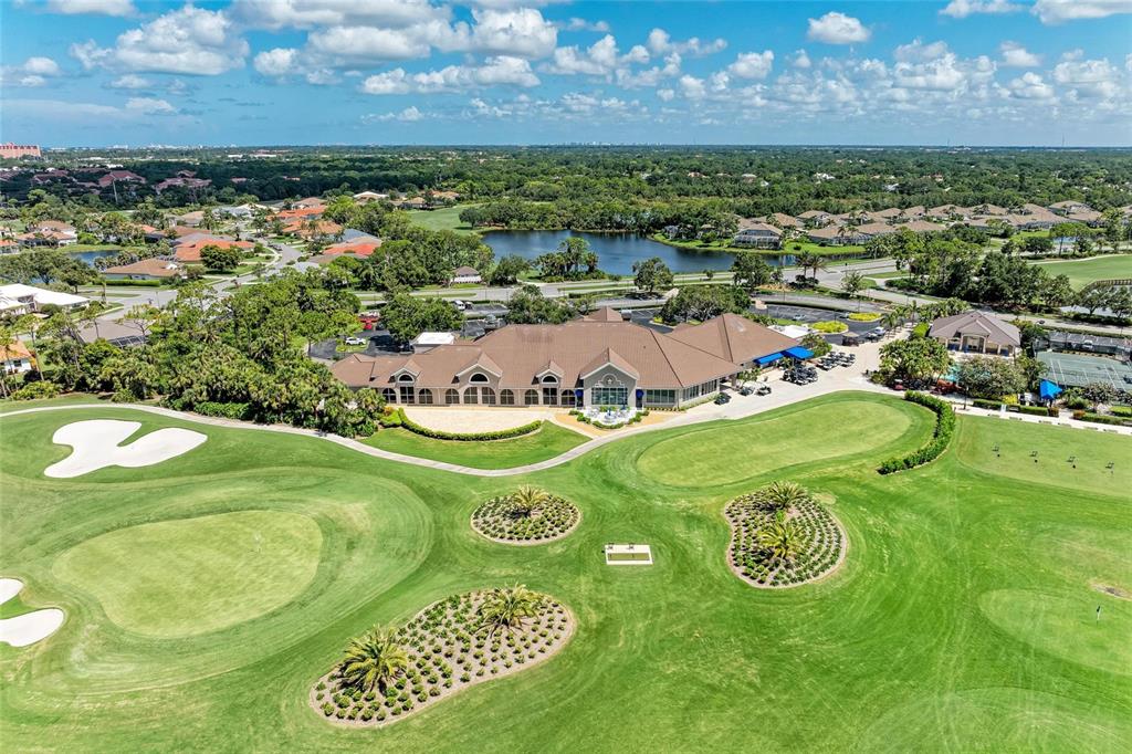 An aerial view shows a large clubhouse building surrounded by a golf course and lake — 9560 HIGH GATE DRIVE UNIT 1626, SARASOTA, FL