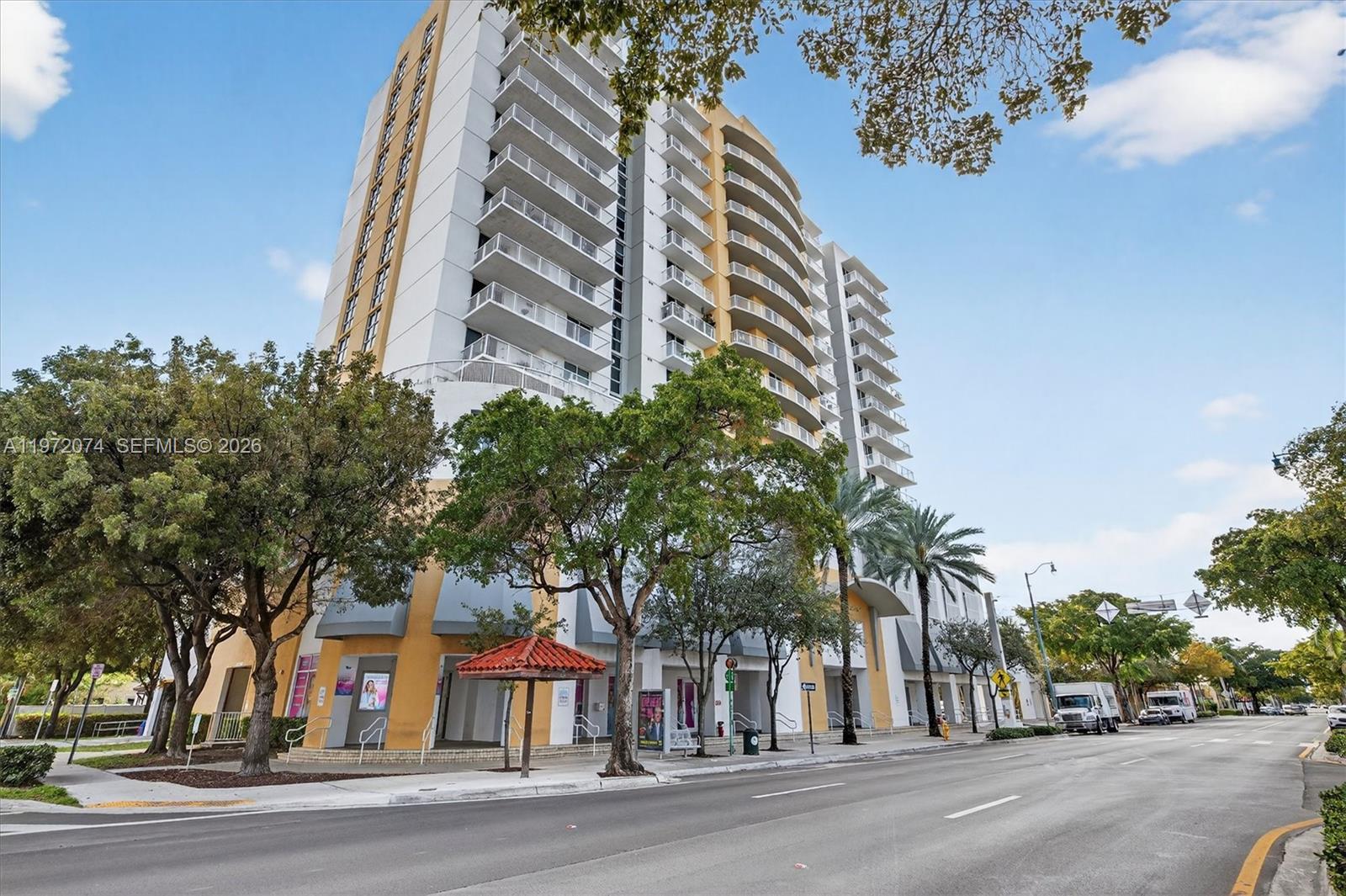 A multi-story residential building with balconies stands along a street with trees and sidewalks — 900 SW 8th St # 505, Miami FL 33130, MIAMI, FL