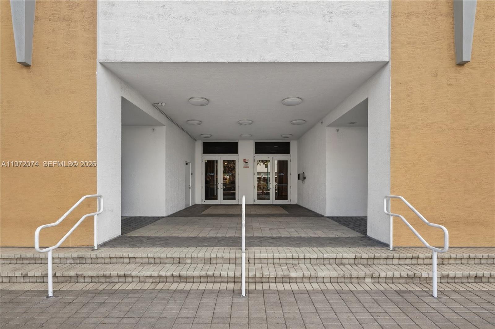 The exterior entrance features a covered walkway with steps, white railings, and glass double doors — 900 SW 8th St # 505, Miami FL 33130, MIAMI, FL