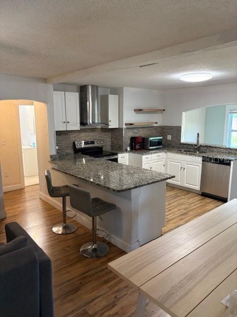 A kitchen features granite countertops, white cabinetry, stainless steel appliances, and a breakfast bar — 4035 14TH AVENUE S, ST PETERSBURG, FL