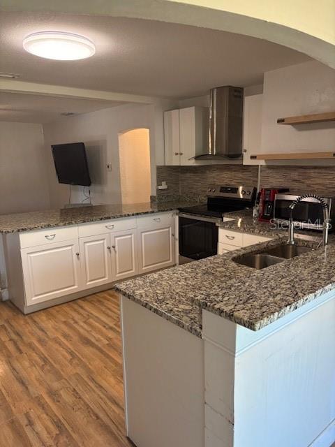 A kitchen with white cabinets, granite countertops, stainless steel appliances, and wood-look flooring — 4035 14TH AVENUE S, ST PETERSBURG, FL