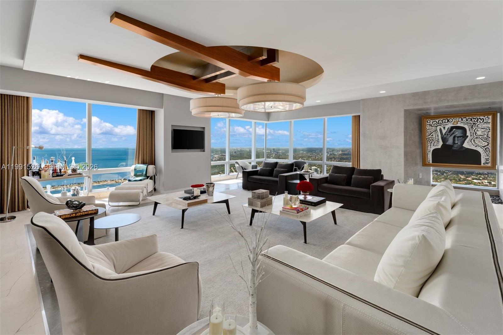 A modern living room features white sofas, dark armchairs, two coffee tables, and floor-to-ceiling windows — 1425 Brickell Ave, Miami FL 33131, MIAMI, FL