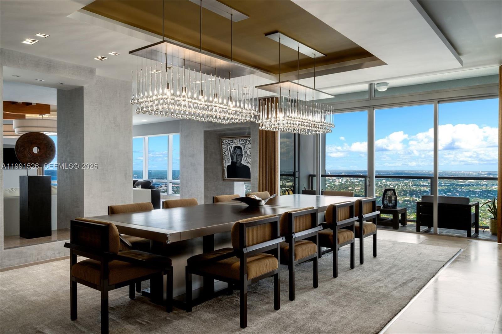 A modern dining room features a long table, two crystal chandeliers, and floor-to-ceiling windows — 1425 Brickell Ave, Miami FL 33131, MIAMI, FL
