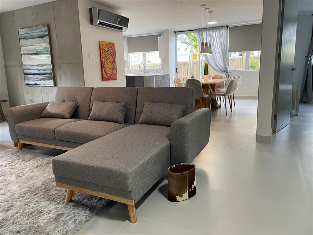 A gray sectional sofa sits in a living room with tile floors and an adjacent dining area — 290 SANTA ANA AVENUE, GUAYNABO, PR