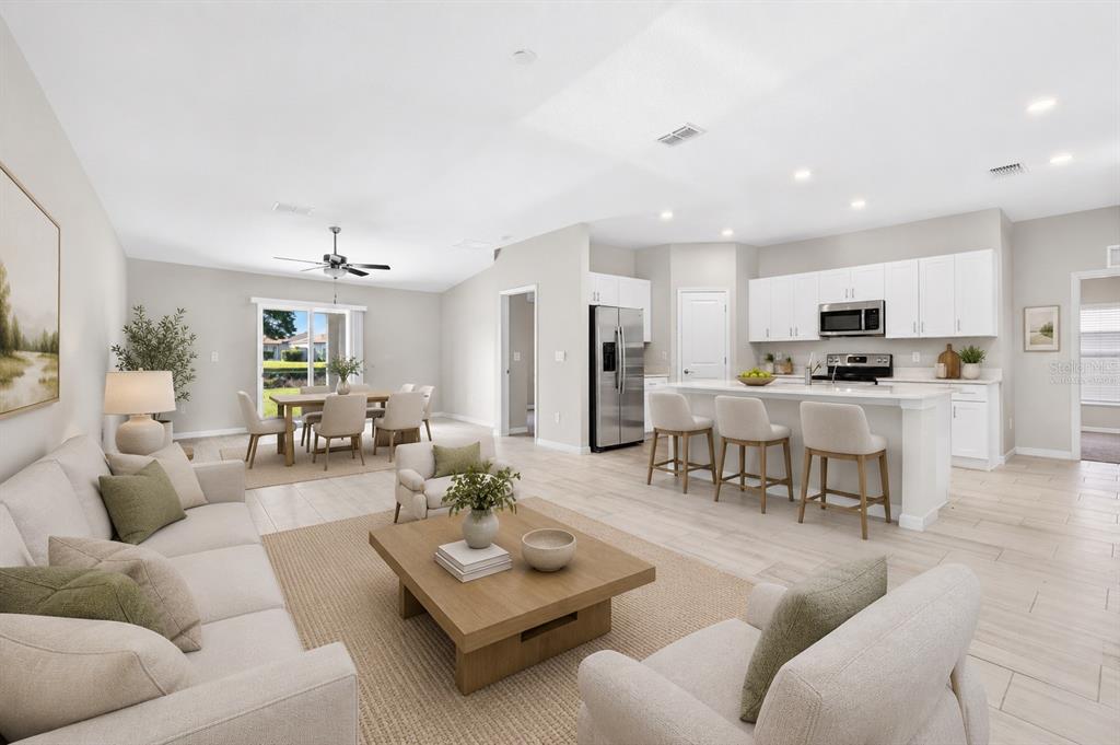 An open-concept living room, dining area, and kitchen with light tile floors and white cabinetry — 13187 PALMERSTON ROAD, RIVERVIEW, FL