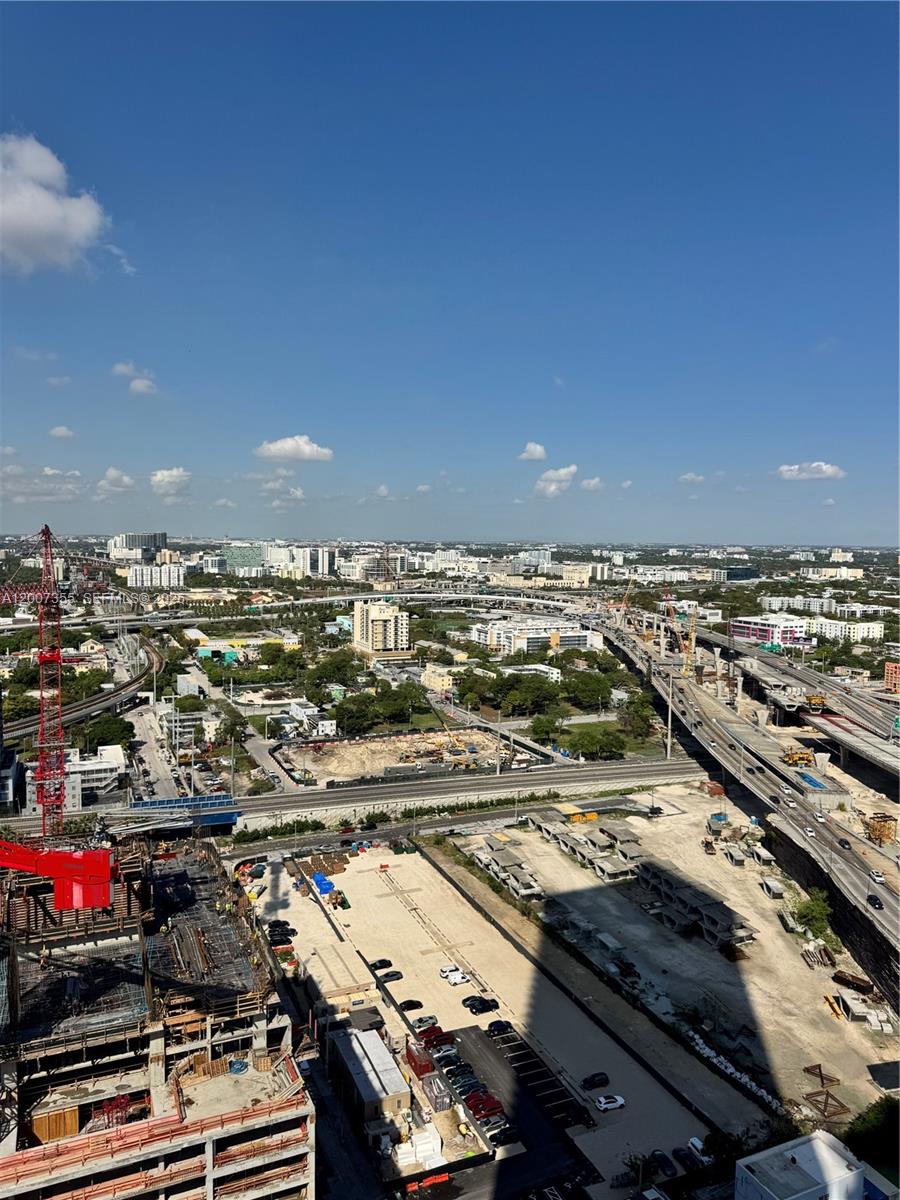 An elevated view shows a construction site, highway overpasses, and urban buildings under a blue sky — 20 NE 11th St # 3012A, Miami FL 33132, MIAMI, FL