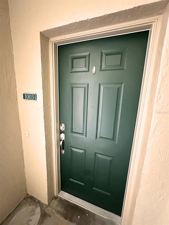 A green six-panel front door with a silver handle and the number 1003 — 1003 EAGLE POND DRIVE UNIT 1003, WINTER HAVEN, FL