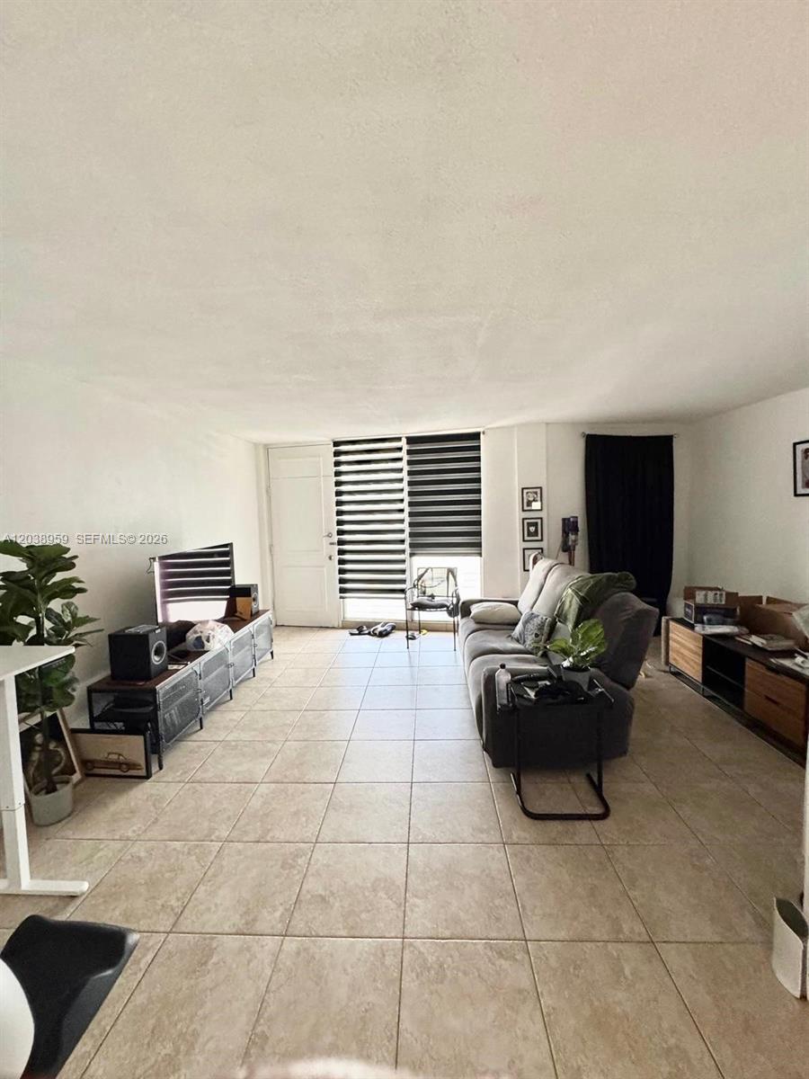 A living room features light tile flooring, a gray sofa, and a television console — 1100 Alton Rd # 5D, Miami Beach FL 33139, MIAMI BEACH, FL