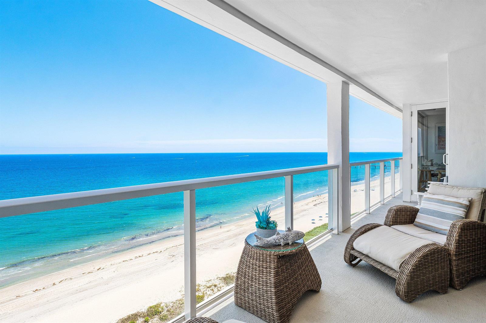 A balcony with wicker furniture overlooks a sandy beach and the blue ocean — 2800 S Ocean Boulevard # 17l, Boca Raton FL 33432, BOCA RATON, FL