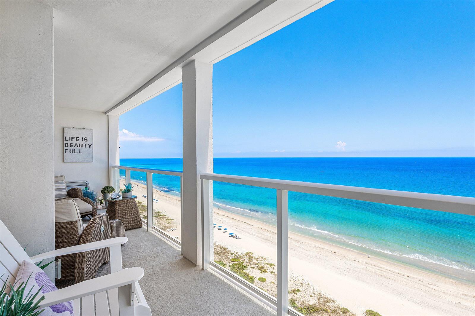 A balcony with wicker furniture overlooks a sandy beach and the blue ocean — 2800 S Ocean Boulevard # 17l, Boca Raton FL 33432, BOCA RATON, FL