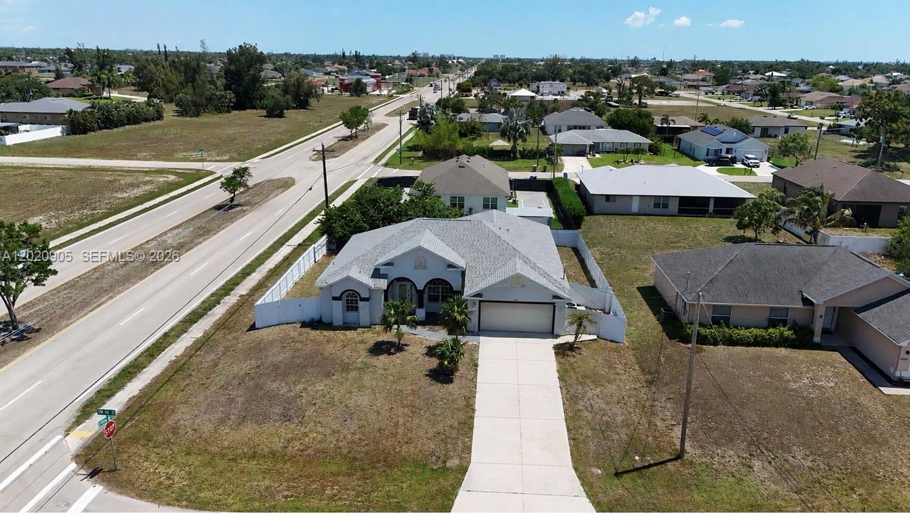An aerial view shows a single-story house with a white exterior and a gray roof — 1602 SW 14th St, Cape Coral FL 33991, CAPE CORAL, FL