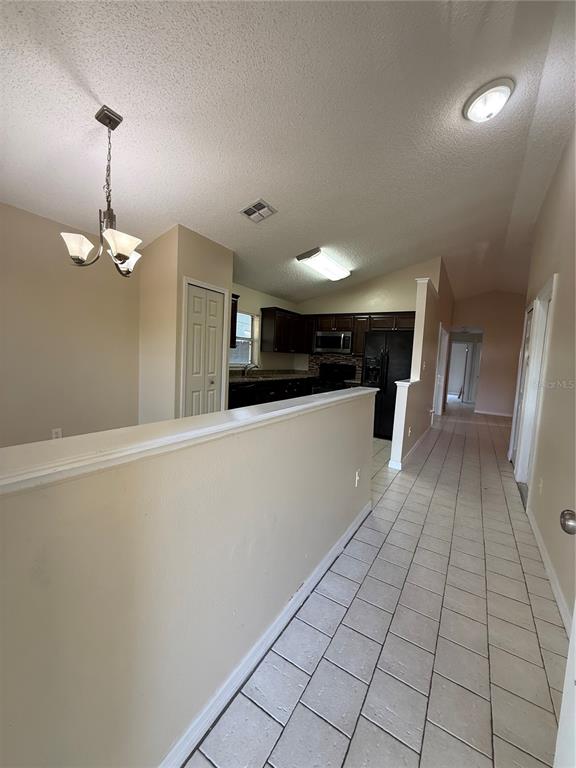 A kitchen with dark cabinets and tile flooring is visible beyond a half wall — 776 WOLF CREEK COURT, APOPKA, FL