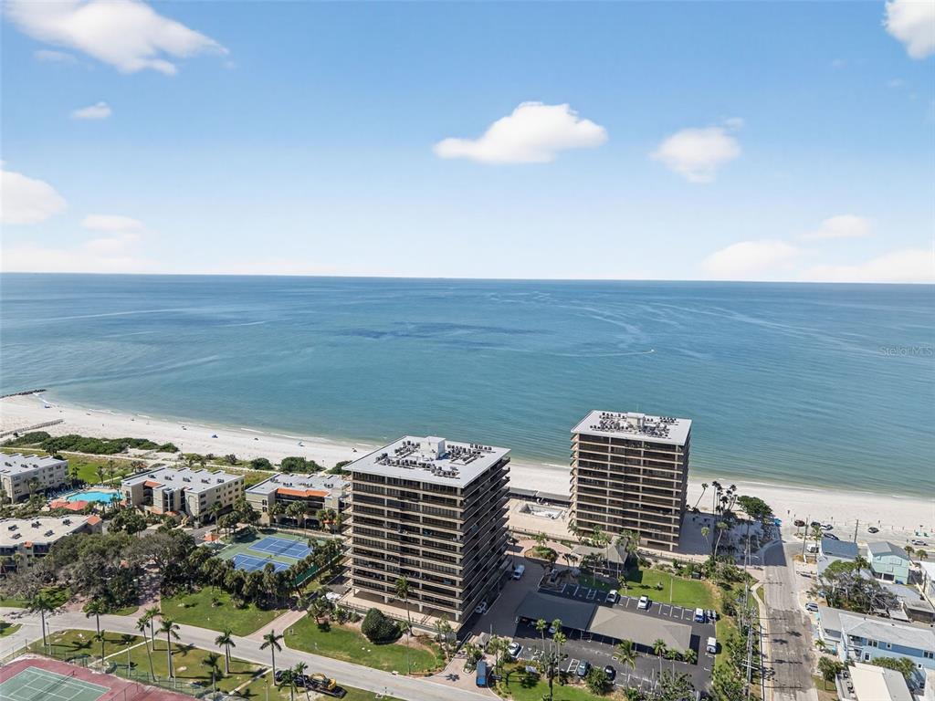 An aerial view shows two high-rise apartment buildings located on a sandy beach — 7600 BAYSHORE DRIVE UNIT 902, TREASURE ISLAND, FL