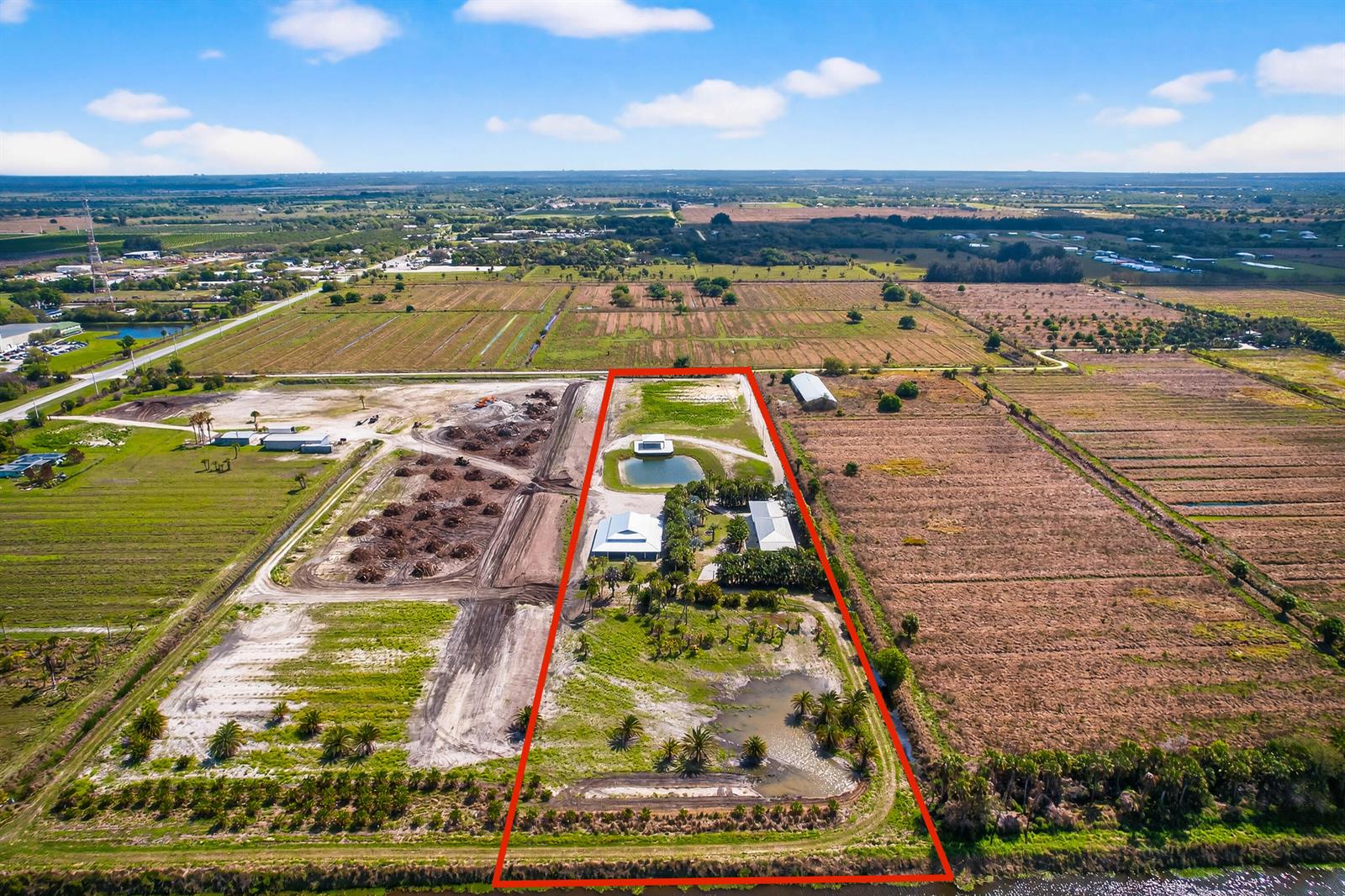 An aerial view shows a rectangular property with buildings, a pond, and surrounding agricultural land — 200 S Graves Road, Fort Pierce FL 34945, FORT PIERCE, FL