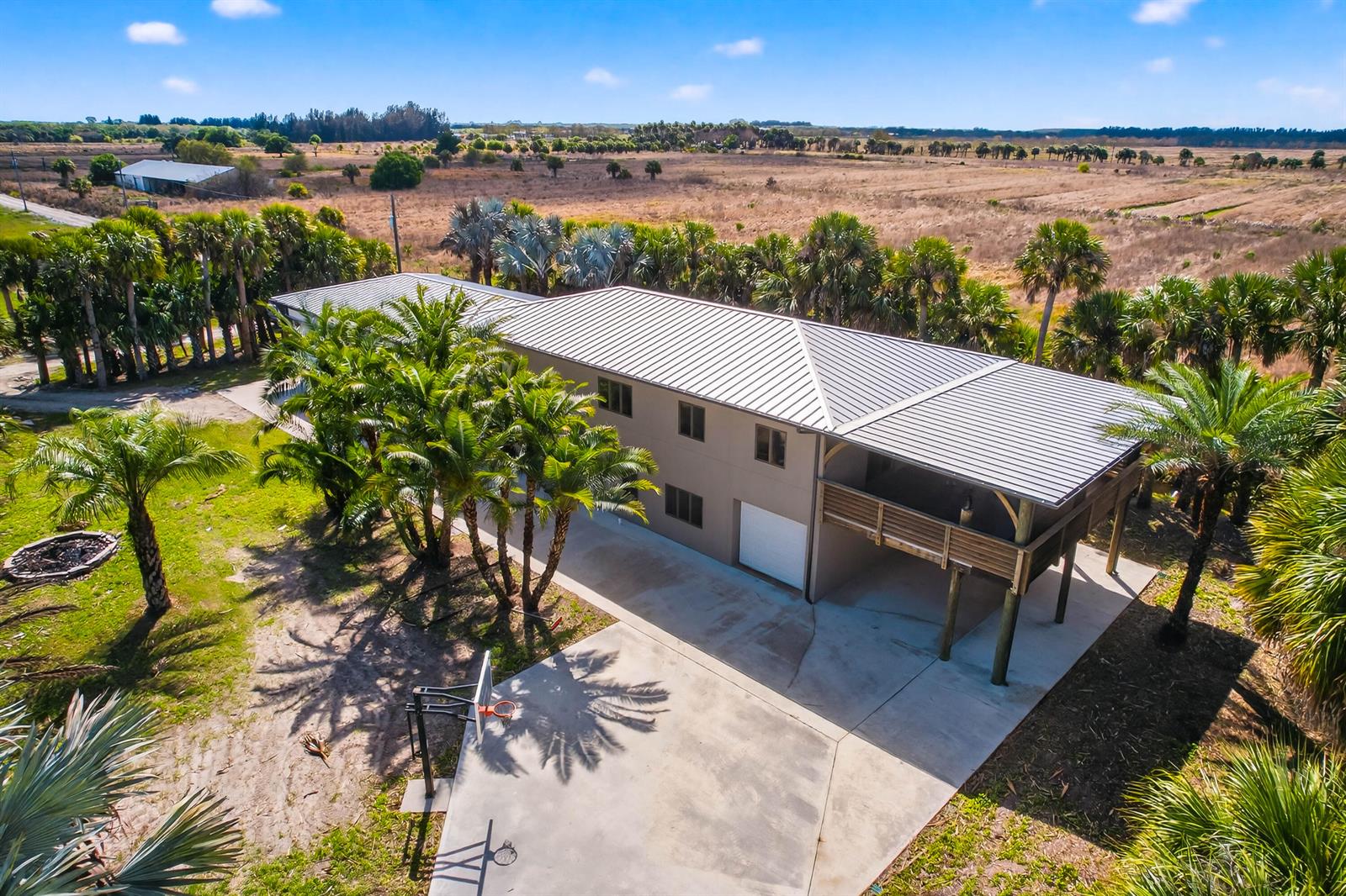 An aerial view shows a two-story house with a metal roof and a concrete driveway — 200 S Graves Road, Fort Pierce FL 34945, FORT PIERCE, FL