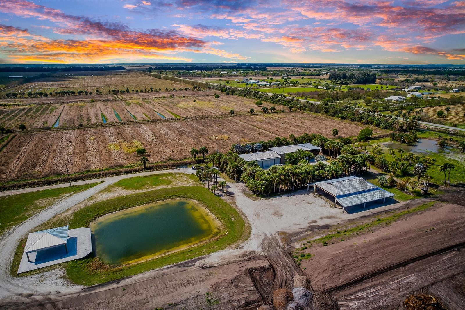 An aerial view shows a rural property with a house, outbuildings, a pond, and fields — 200 S Graves Road, Fort Pierce FL 34945, FORT PIERCE, FL