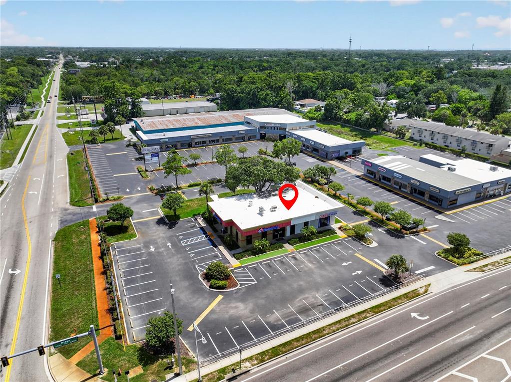 An aerial view shows a commercial building with a Domino's pizza restaurant and parking lots — 6486 E RIDGE ROAD E, PORT RICHEY, FL