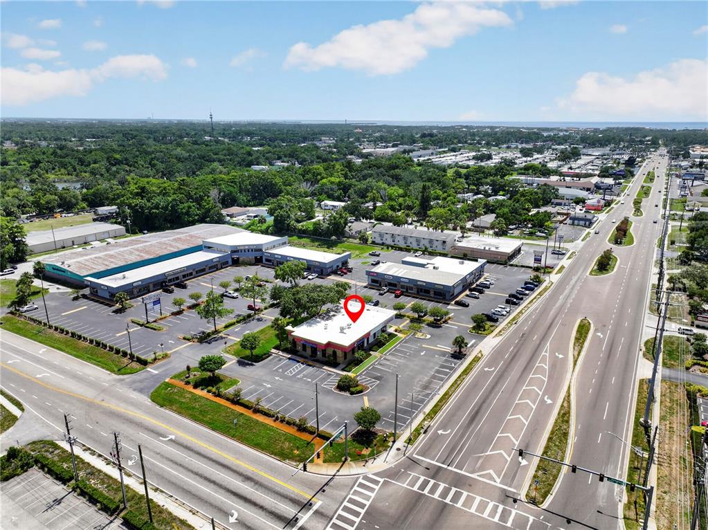 An aerial view shows a commercial plaza with a standalone building marked by a pin — 6486 E RIDGE ROAD E, PORT RICHEY, FL