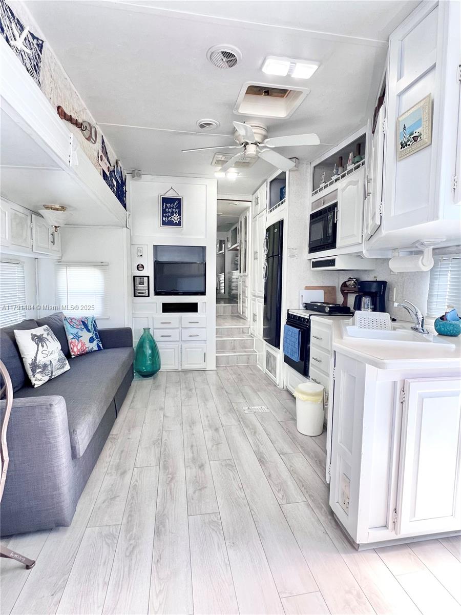A bright, coastal-themed living room and kitchen area inside a recreational vehicle — 325 Calusa St #5, Key Largo FL 33037, KEY LARGO, FL