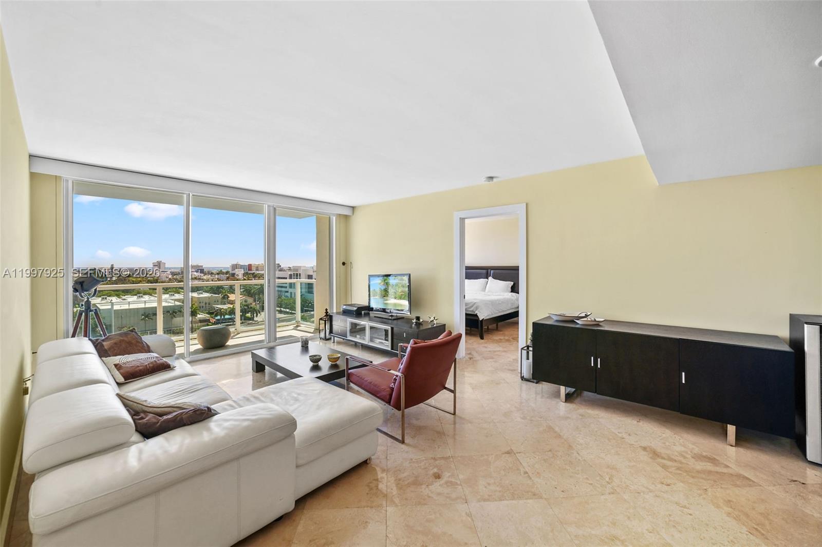 A living room features a white sectional sofa, a red armchair, and tile flooring — 650 West Ave # 1104, Miami Beach FL 33139, MIAMI BEACH, FL