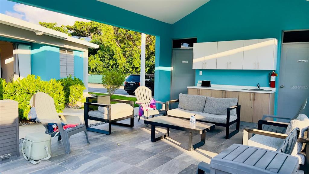 An outdoor patio area features a seating group, a kitchenette, and light blue walls — 3418 CALLE UROYUAN, RINCON, PR