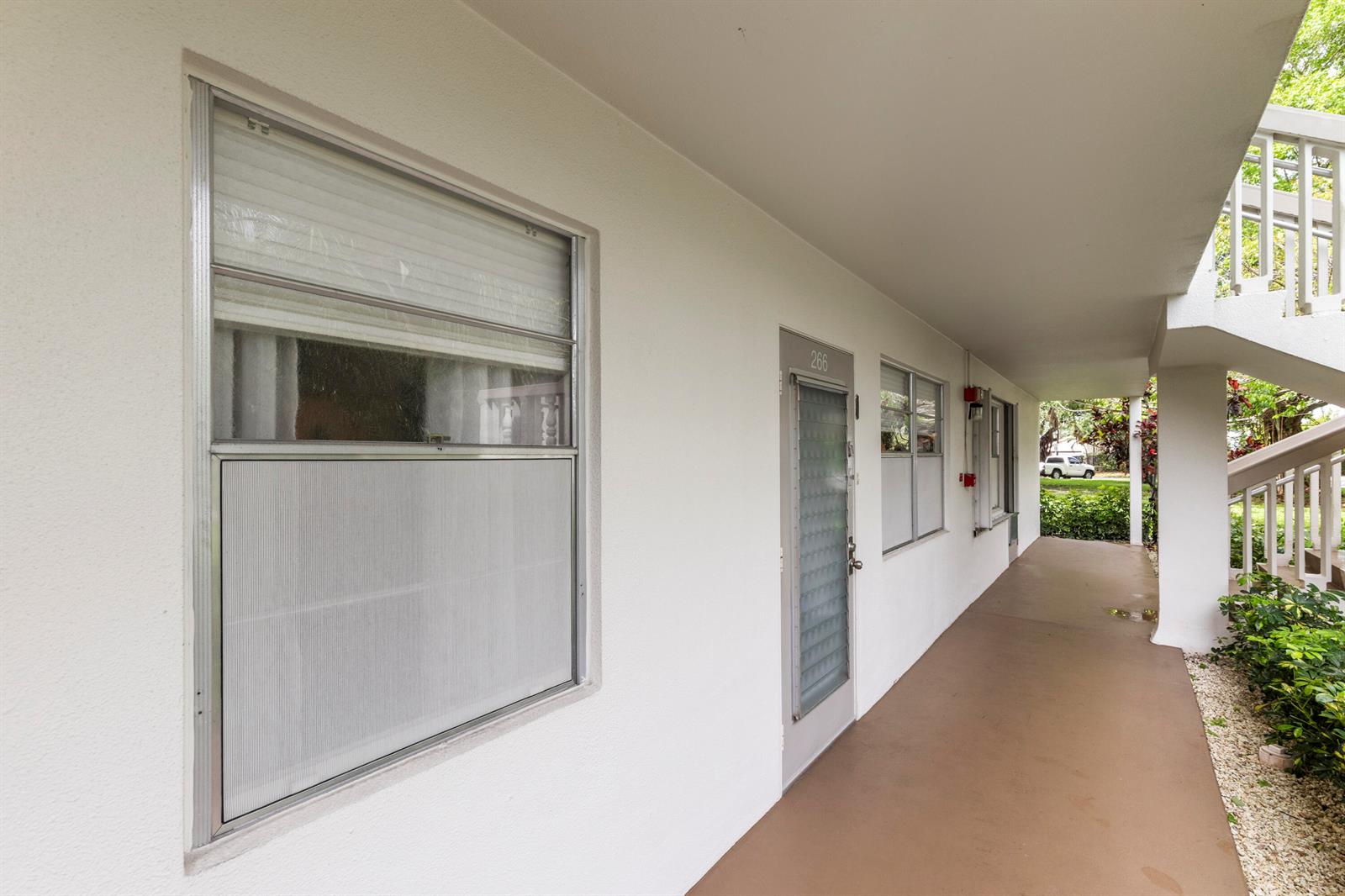An exterior walkway leads to the entrance of a residential unit with a numbered door — 266 Ventnor S, Deerfield Beach FL 33442, DEERFIELD BEACH, FL