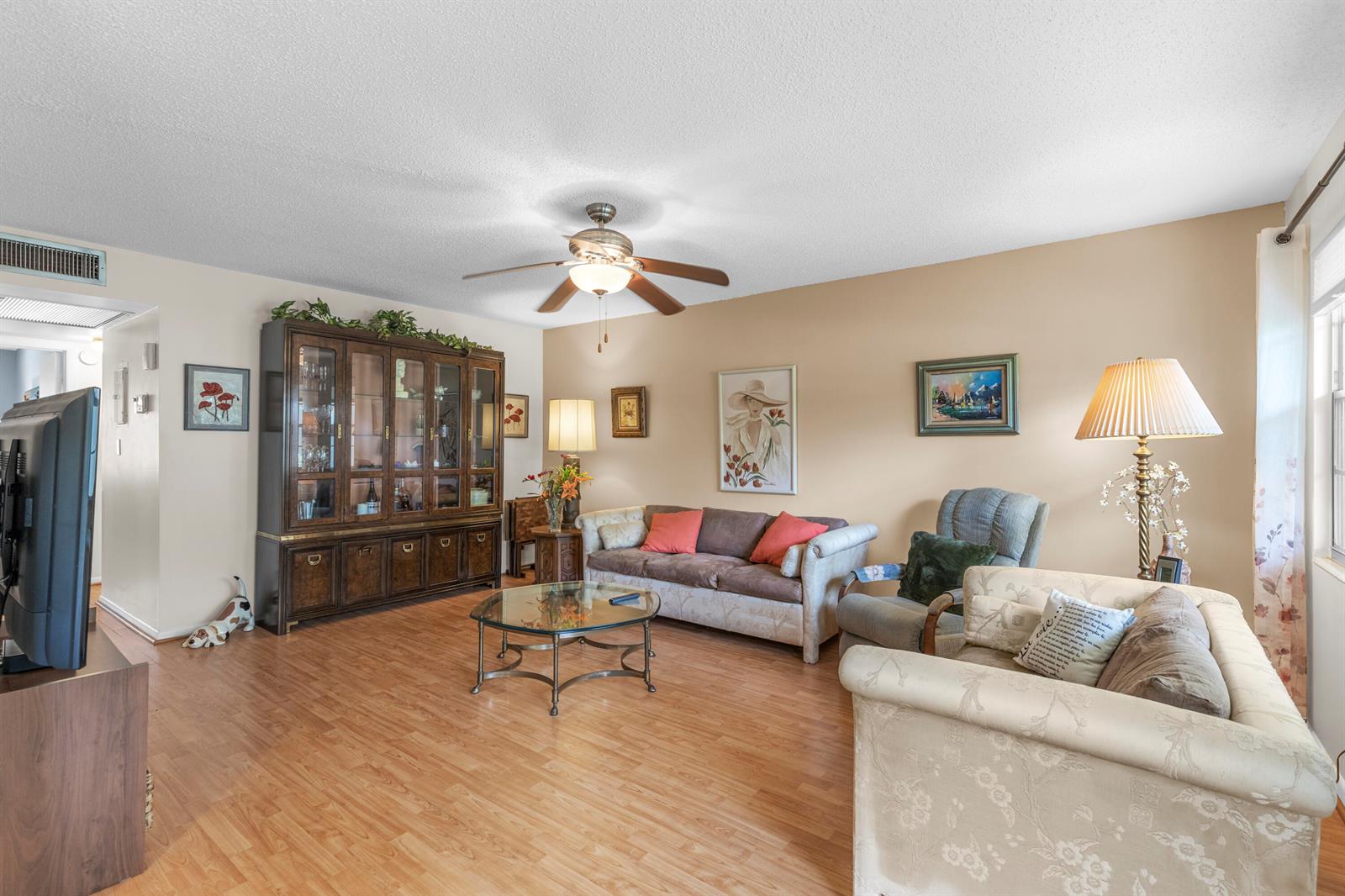 A living room features wood-look flooring, a ceiling fan, a glass coffee table, and furniture — 266 Ventnor S, Deerfield Beach FL 33442, DEERFIELD BEACH, FL