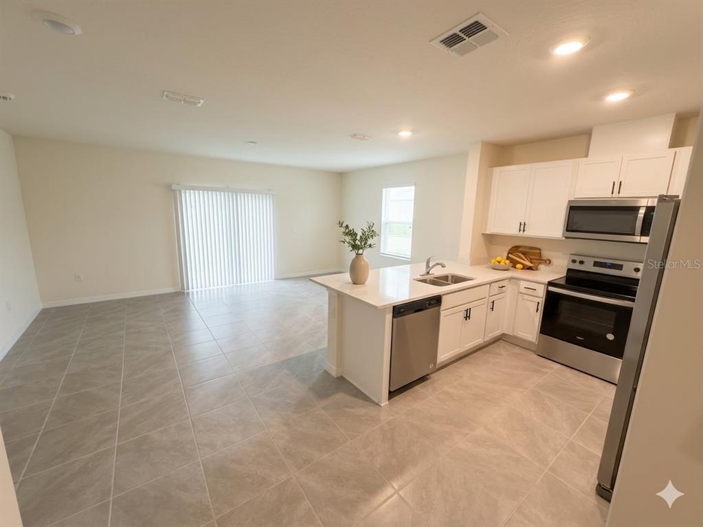 An entryway features a white front door with a transom window, tile flooring, and carpeted stairs — 2730 PUFFIN PLACE, DAVENPORT, FL