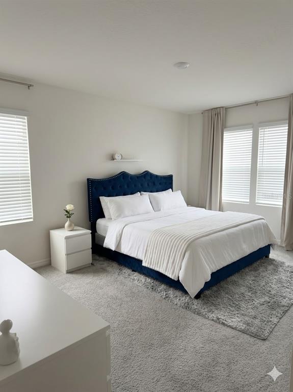 A hallway with tiled flooring leads to a white front door with multiple interior doors — 2730 PUFFIN PLACE, DAVENPORT, FL