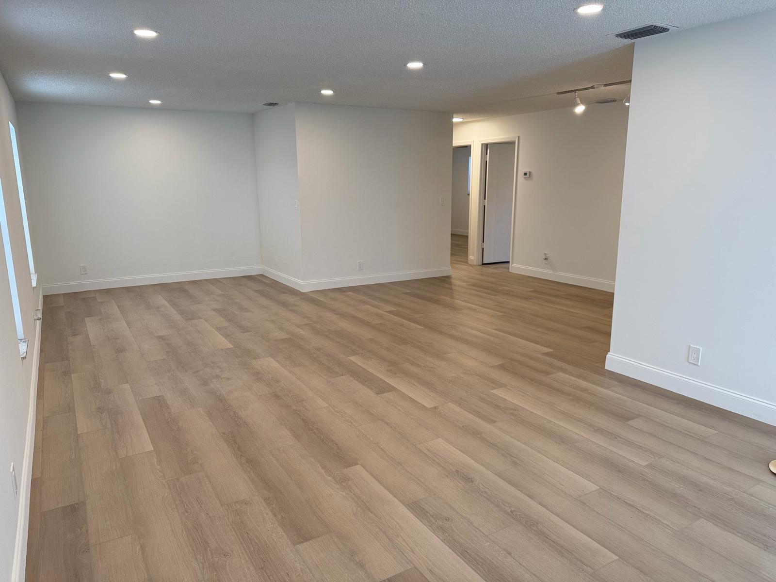 An empty room with light wood-look flooring, white walls, and recessed ceiling lighting — 2630 W 28th Street, Riviera Beach FL 33404, RIVIERA BEACH, FL