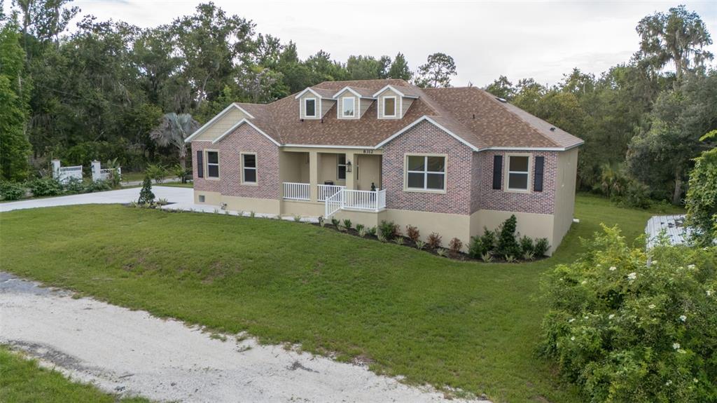 A wooden dock with two blue chairs sits on a quiet, tree-lined creek — 8312 REVELS ROAD, RIVERVIEW, FL