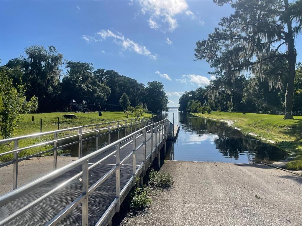 A boat ramp and metal dock lead into a narrow canal surrounded by trees — 430 SE 74TH STREET, GAINESVILLE, FL
